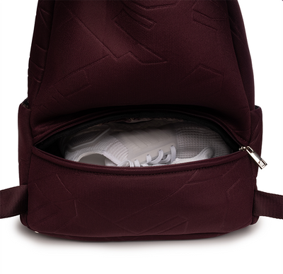 Separate zip footwear compartment on the back of the Maya Backpack #color_bordeaux-mesh